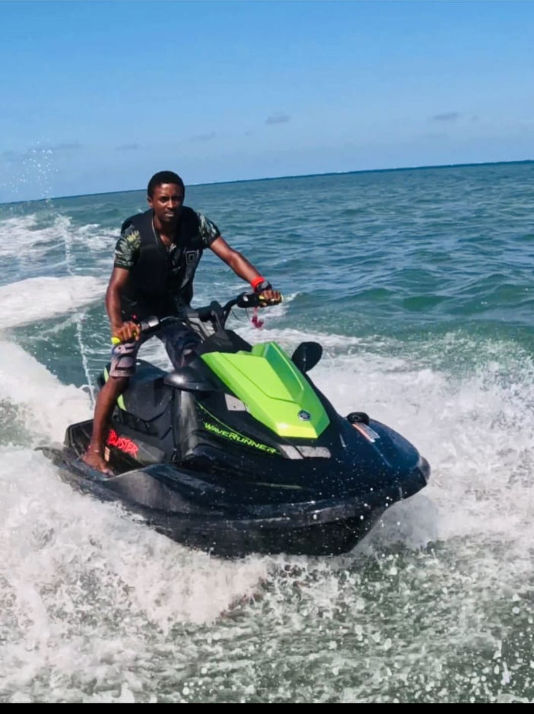 Rider standing on the black and green Yamaha JetBlaster, throwing spray in the turquoise water off Mombasa